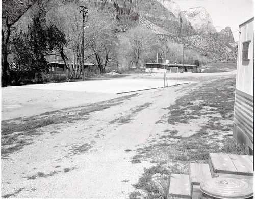 Tennis court at Watchman Housing Area before fencing, with residence Building 37 at head of court.