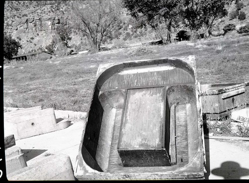 Shop-made form for making cinder concrete, monolithic cast campground fireplaces, in utility area.