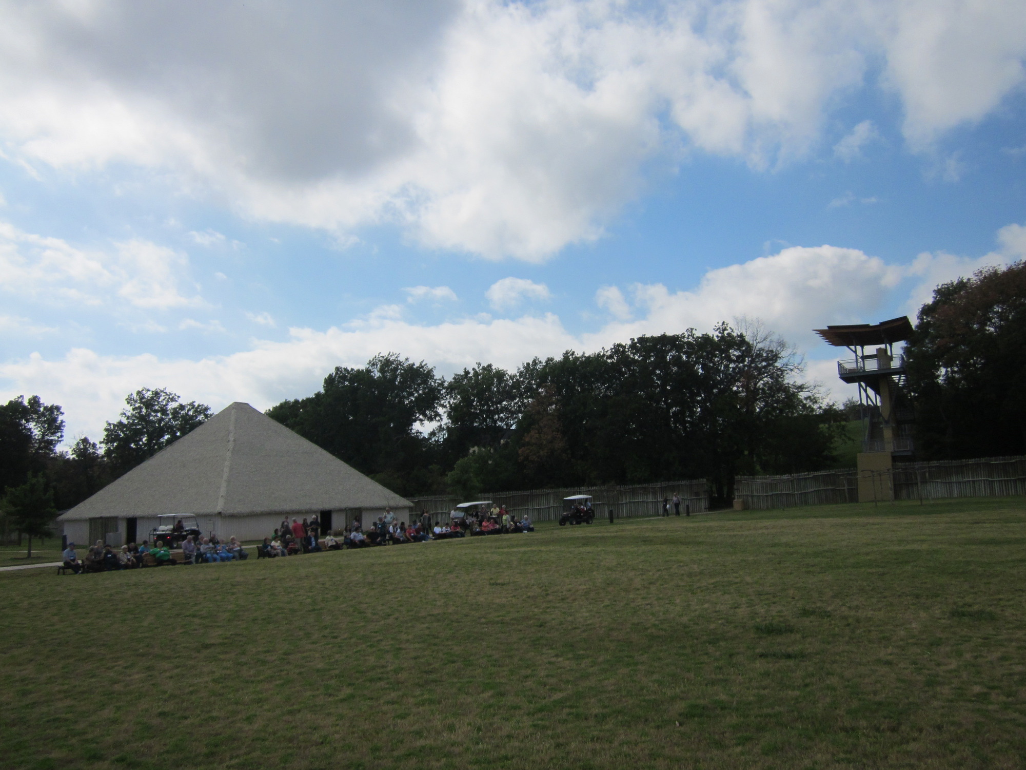 A small house in a grassy area under the cloudy sky.