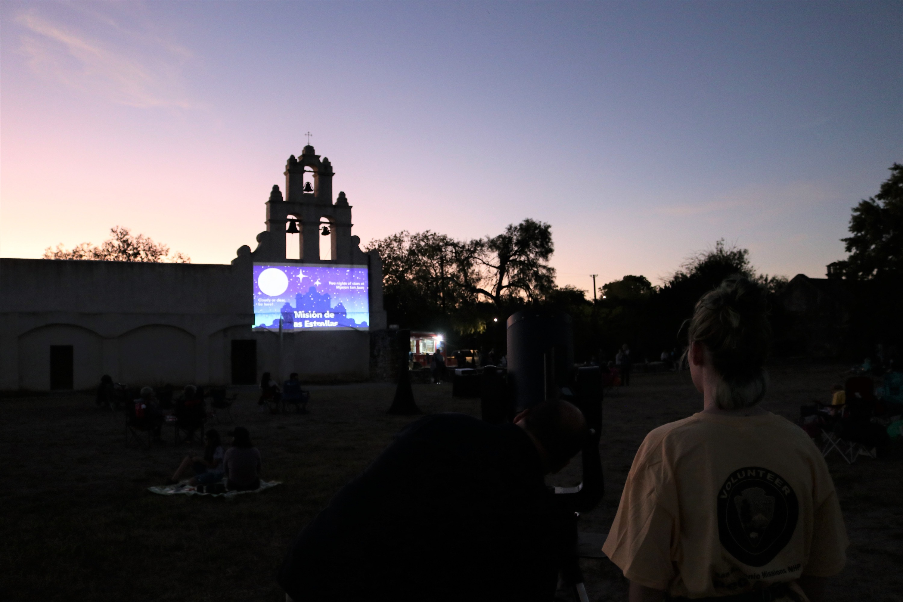 Event Image projected onto church facade with Volunteer in foreground. 
