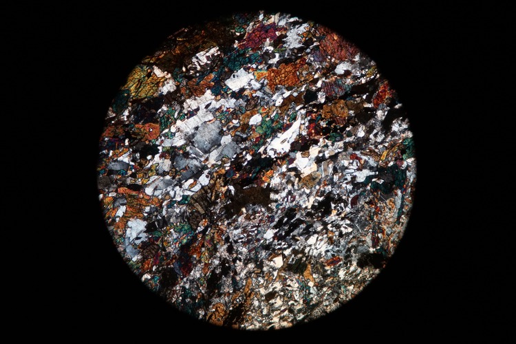 Circular microscopic image of rock structure.