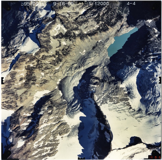 Color aerial photograph of glacier and snowfields on mountain peak.