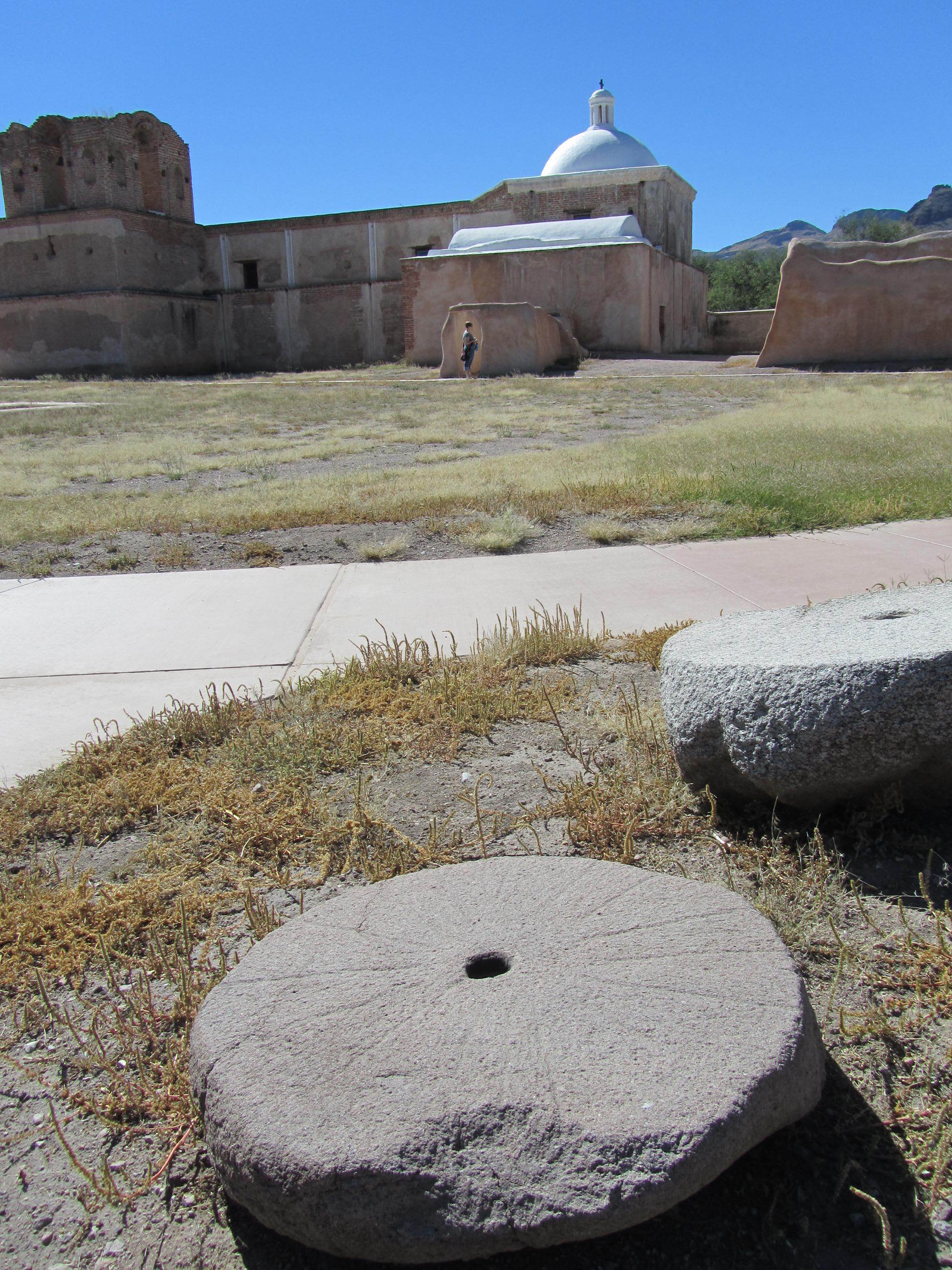 Tumacácori mission church exterior with grinding stone in the foreground