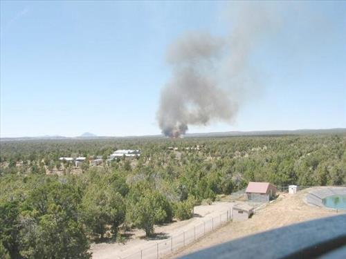 Full fire with black smoke advancing on buildings on the first day of Long Mesa Fire, Mesa Verde National Park, July 29, 2002
