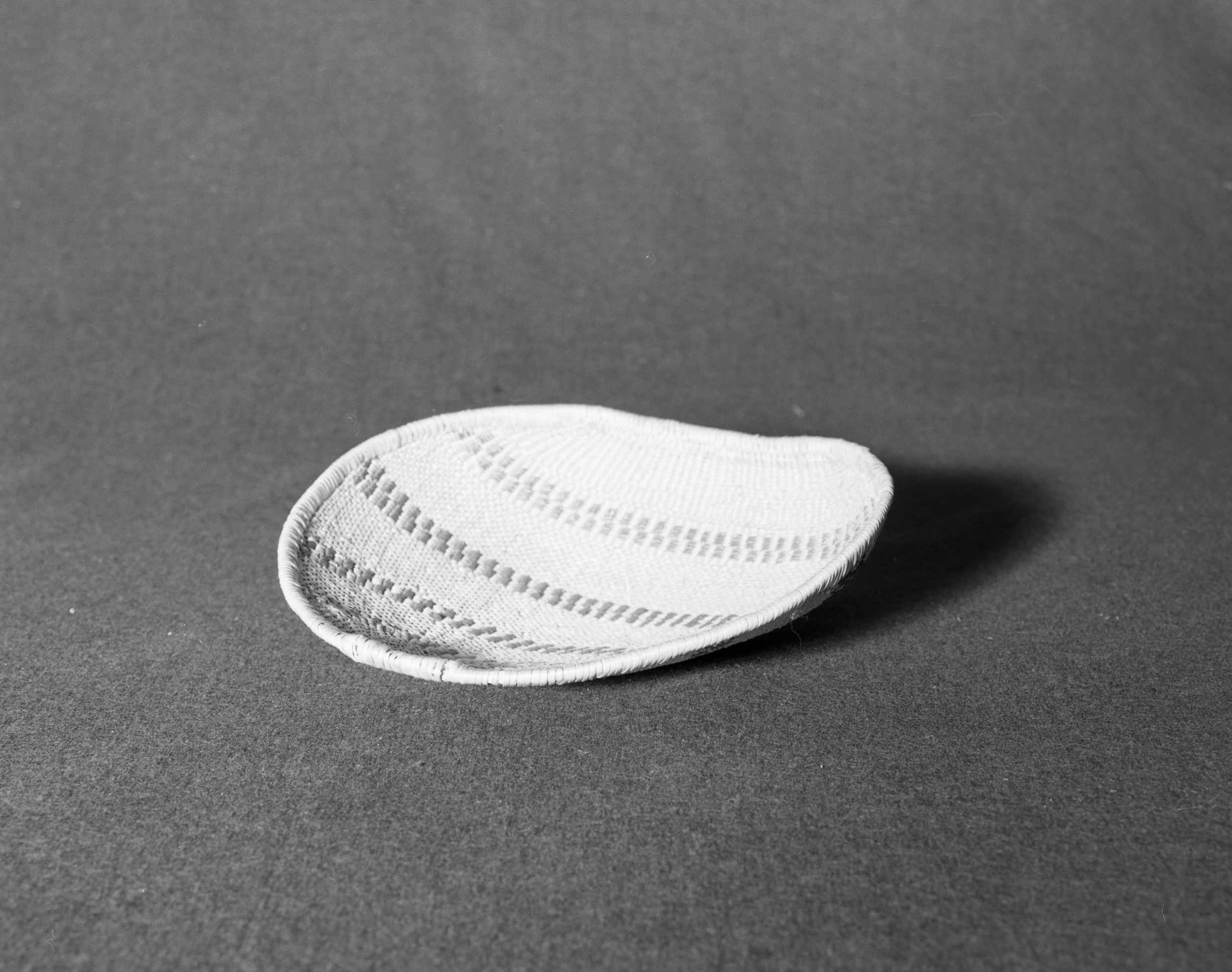 Marie Rozier Collection, Catalog No. 71. Object: Paiute model sifting tray. Dimensions: 9 1/4". Materials: split willow, split redbud, bracken fern root, willow shoots. Technology: up to the right slant of turns, closely stitched coiled rim finish, very fine piece, probably made for sale. Collection History: acquired at Bridgeport from Ella Cane. Photographed from Michael Dixon, Dec. 1982. Catalogued by Craig Bates and Barbara Beroza. Yosemite Collections, National Park Service.