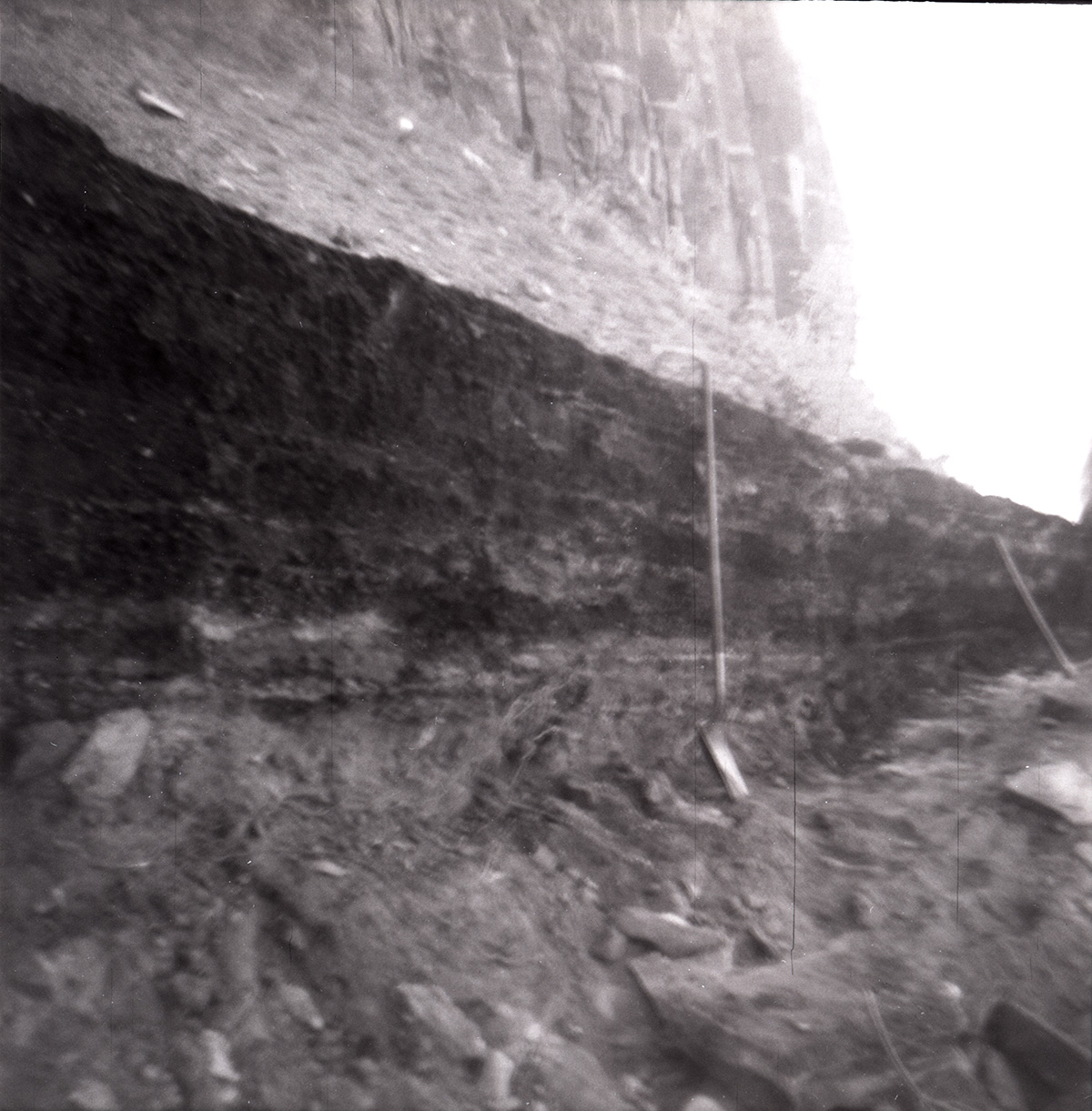 Rock retaining wall alongside road of tunnel during rebuilding.