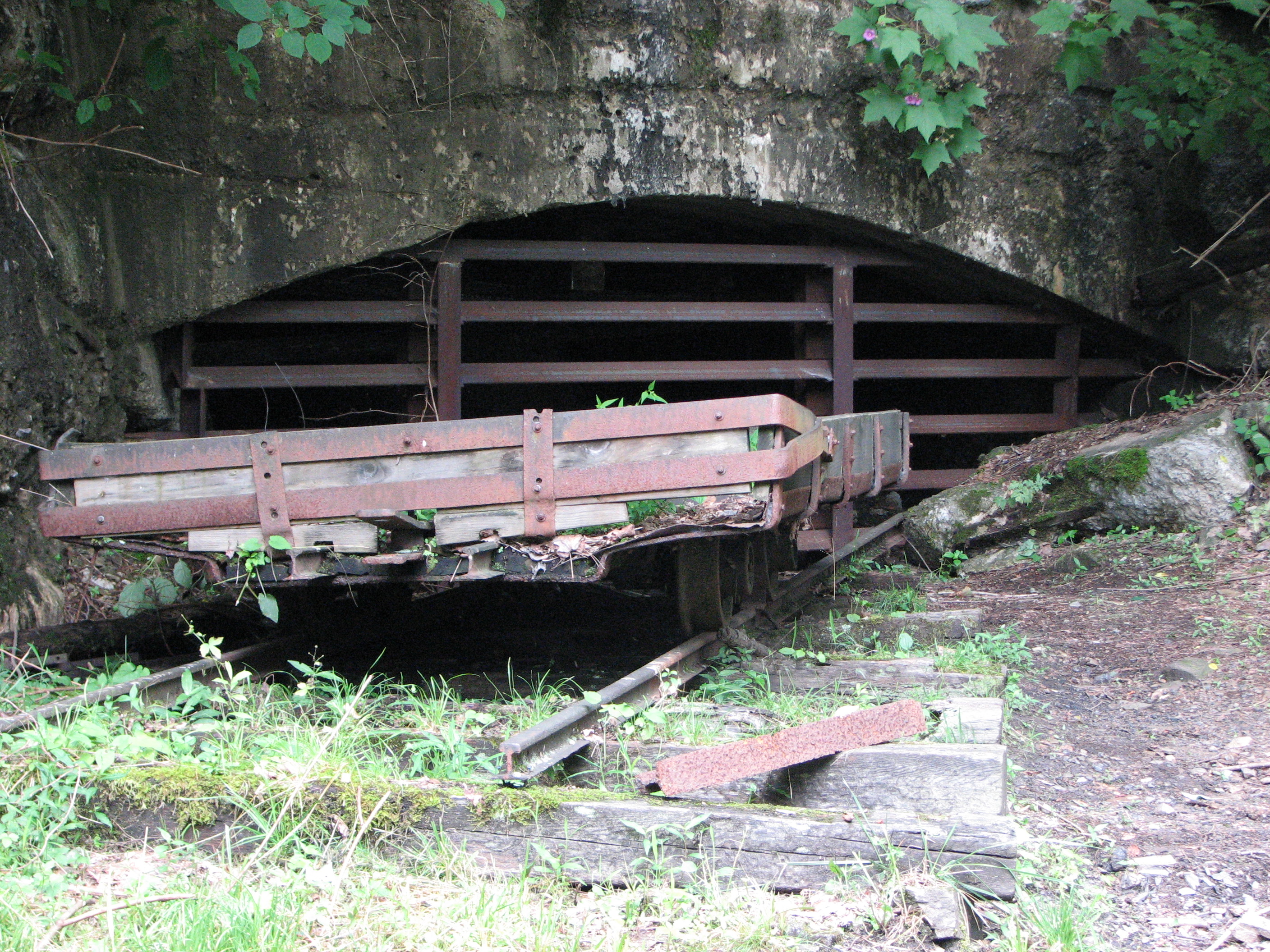 old mine car in front of gated mine entry