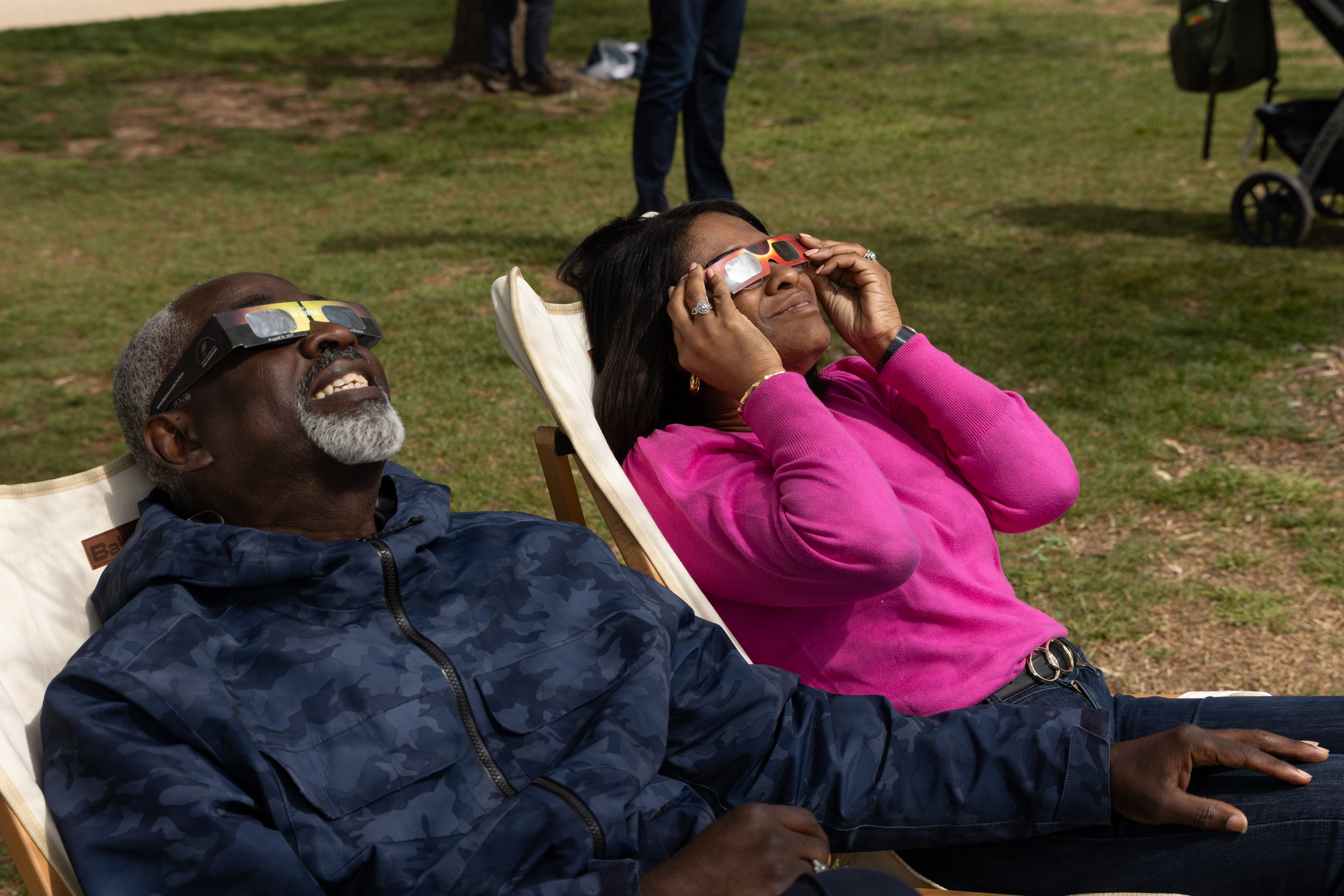 Visitors watch the partial eclipse in lawn chairs on the National Mall lawn