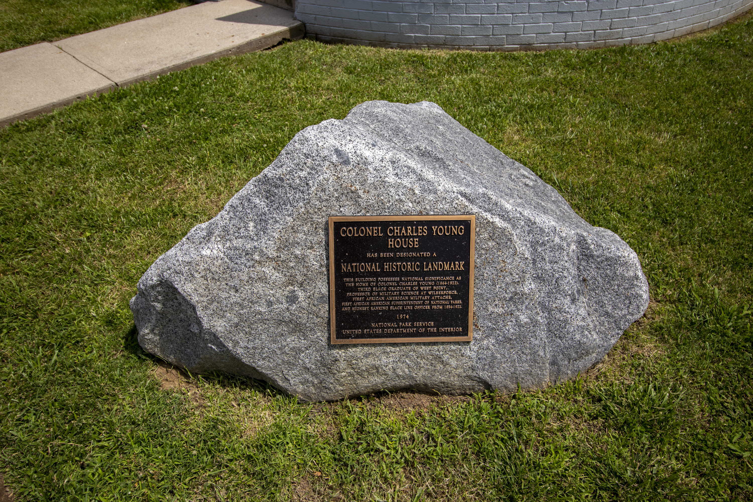 A large gray boulder with a bronze plaque affixed to it, top text reads COLONEL CHARLES YOUNG HOUSE, NATIONAL HISTORIC LANDMARK