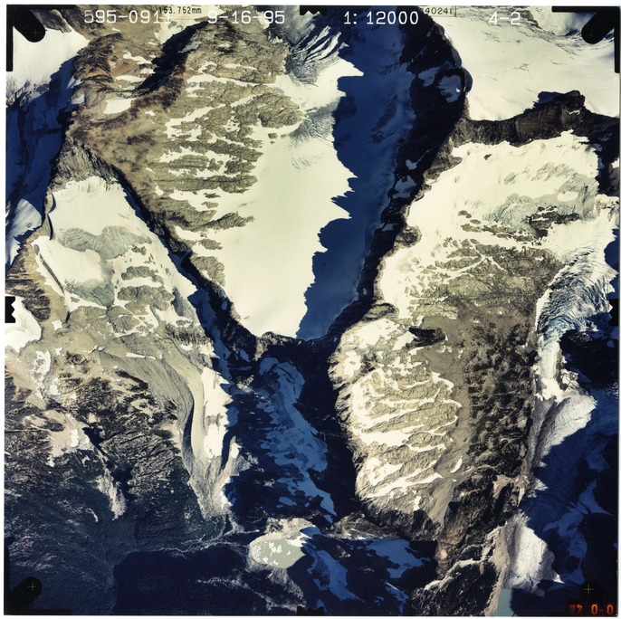 Color aerial photograph of glacier and snowfields on mountain peak.