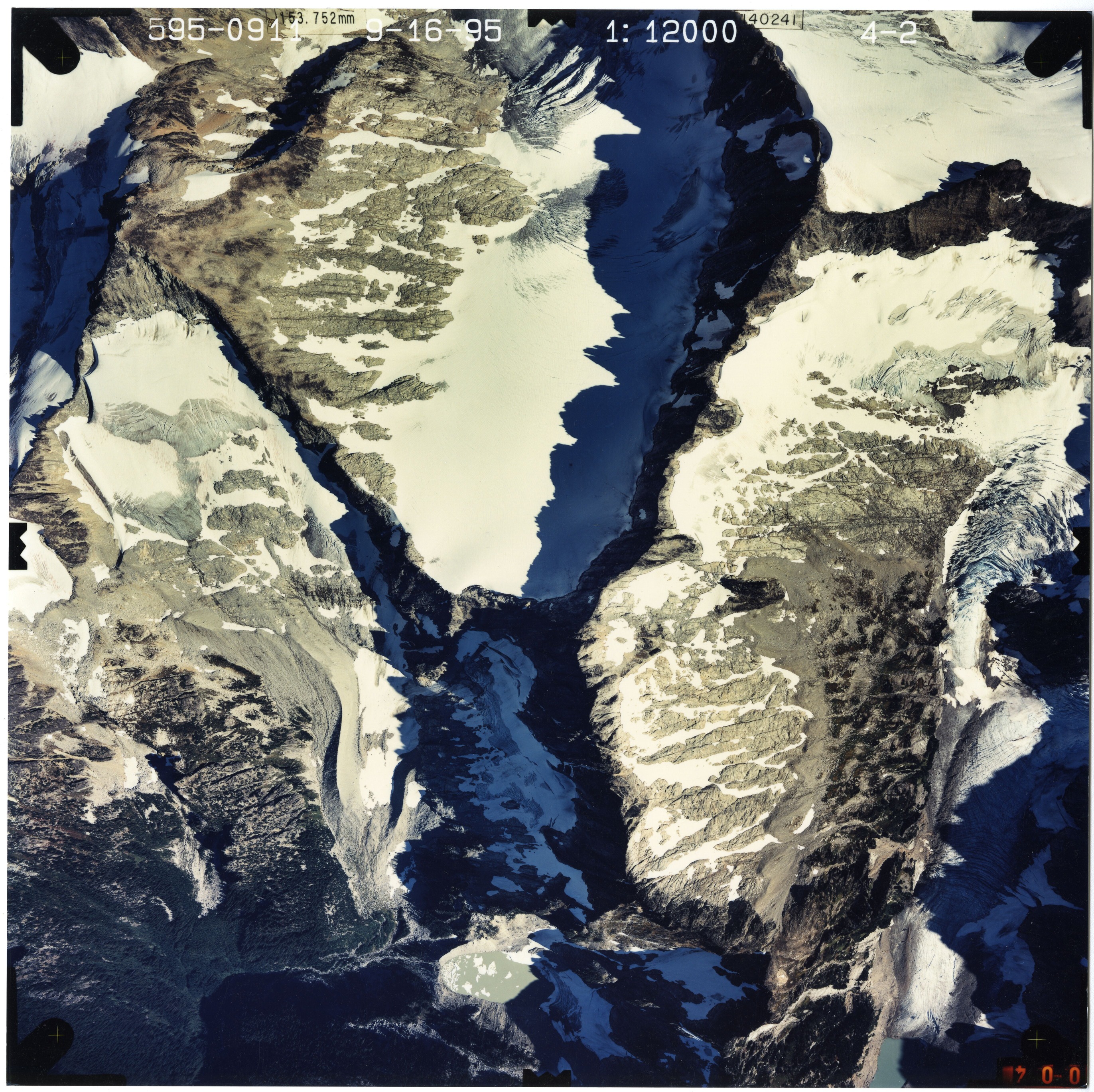 Color aerial photograph of glacier and snowfields on mountain peak.
