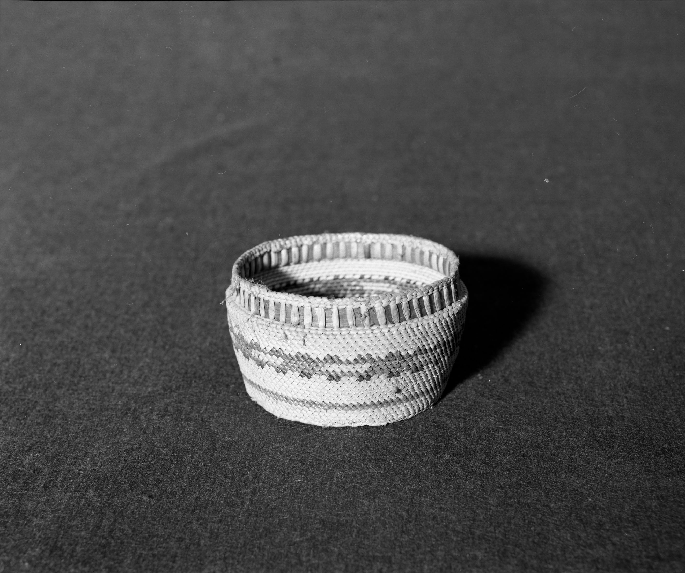 Marie Rozier Collection, Catalog No. 167. Object: Quinault basket. Dimensions: 4 x 2 1/2". Materials: red cedar bark, grass, commercial dye. Technology:---. Collection History: Acquired from Ora Doyle. Photographed by Michael Dixon, Dec. 1982. Catalogued by Craig Bates and Barbara Beroza. Yosemite Collections, National Park Service.