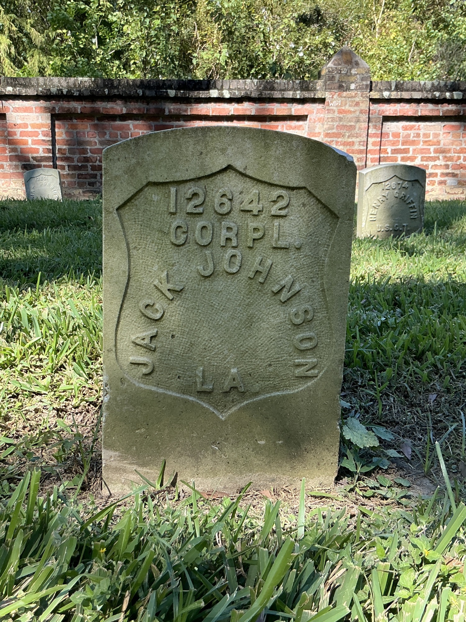 Front of historic upright marble headstone with recessed shield face.