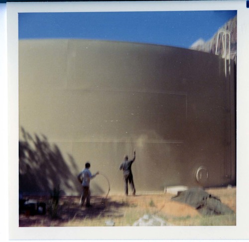 Workers repainting the exterior of the million gallon water tank at Birch Creek.
