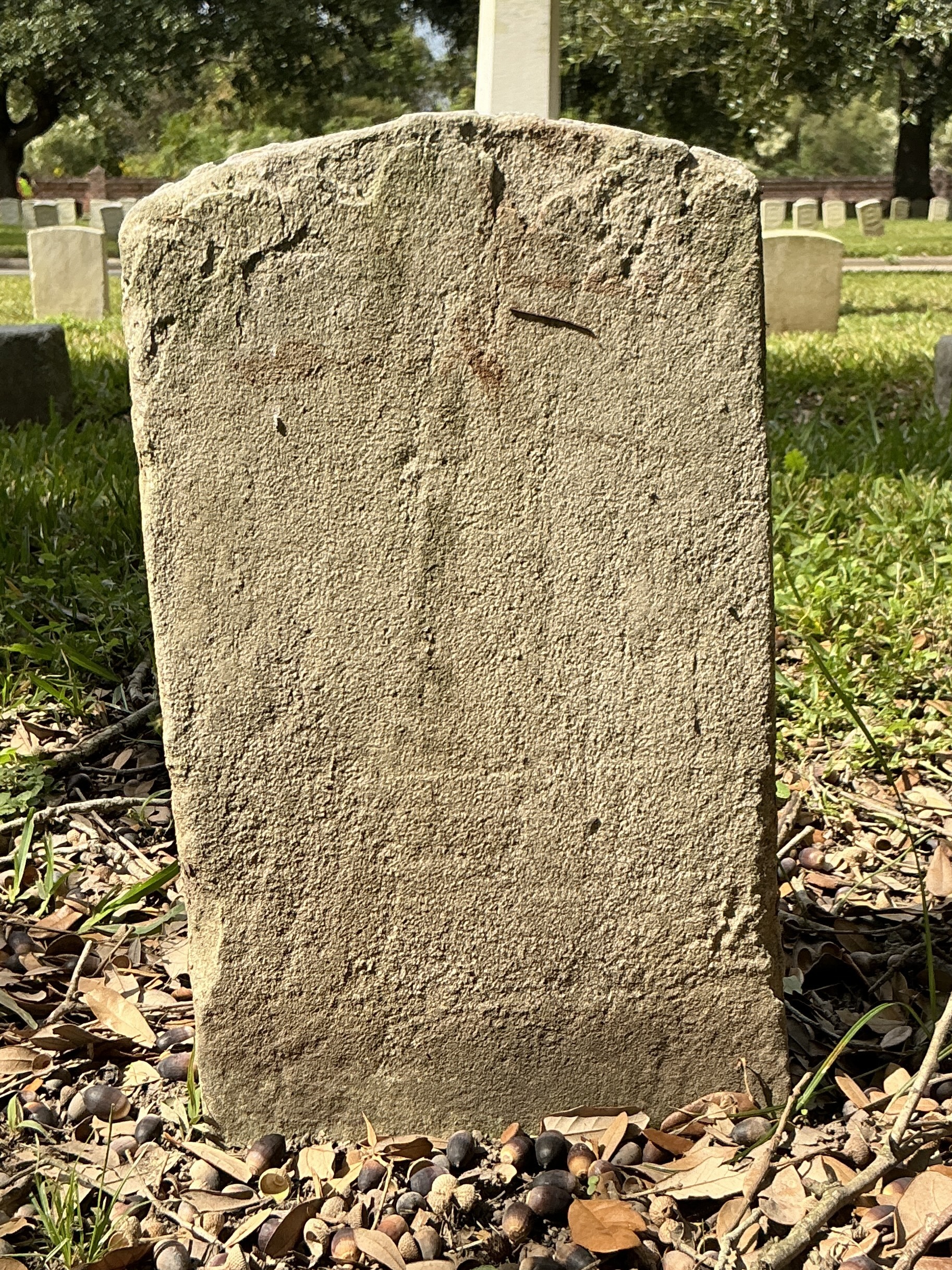 Back of historic upright marble headstone with recessed shield face.