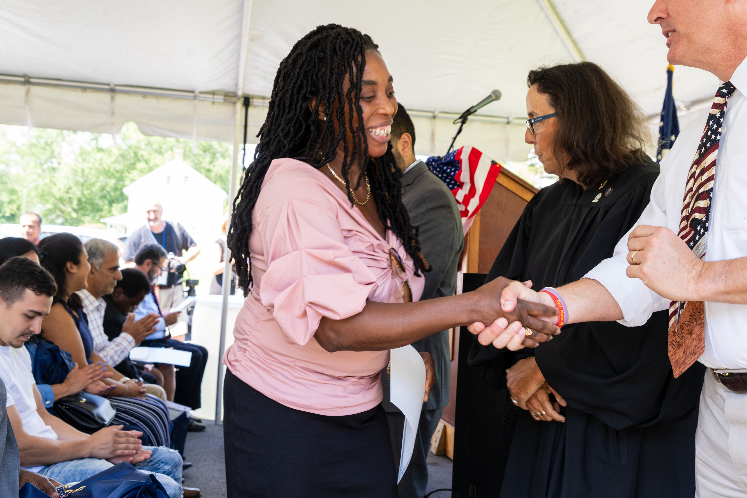 A woman receives a certificate and a hand shake. 