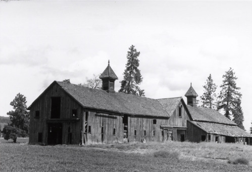 A black and white photo of a barn.