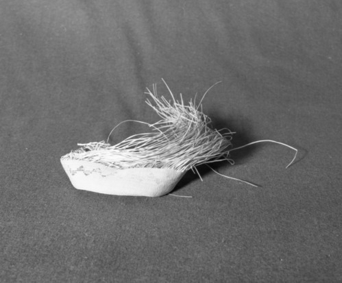 Marie Rozier Collection, Catalog No. 5-7-FM. Object: Unfinished Aleut bag. Dimensions: approximately 5 1/2" x 1'. Materials: seagrass, wool yarn. Technology: plain twined, down to right slant of turns. Collection History: Gift of Flora Hill McCullough. Photographed by Michael Dixon, December 1982. Catalogued by Craig Bates and Barbara Beroza. Yosemite Collections, National Park Service.