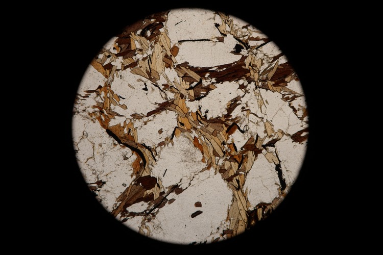 Circular microscopic image of rock structure.
