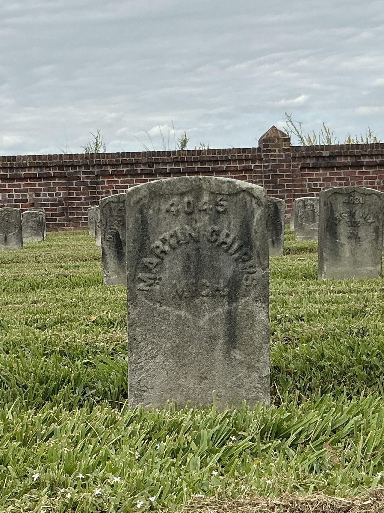 Front of historic upright marble headstone with recessed shield face.