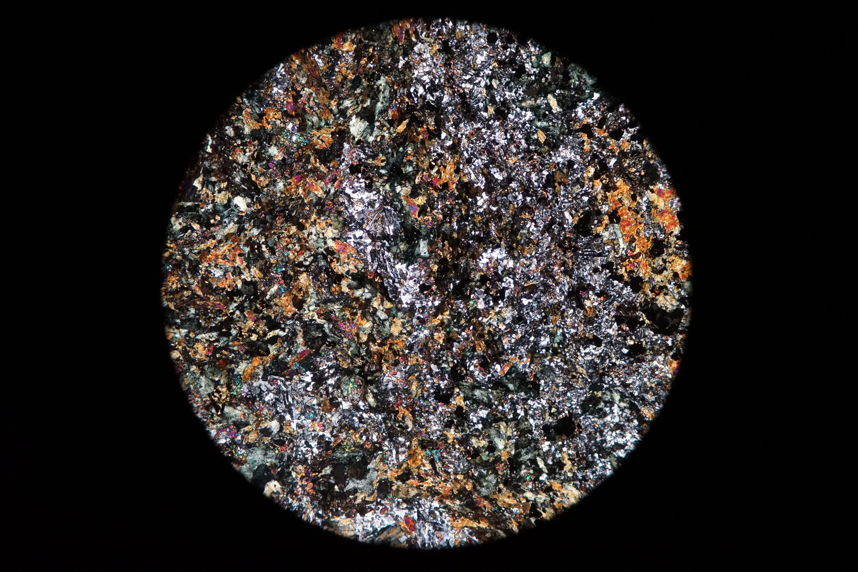 Circular microscopic image of rock structure.