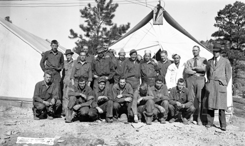 The Civilian Conservation Corps (CCC) trail construction crew assembled in front of a tent at the Jolley Wash spike camp (temporary camp sometimes referred to as the stub camp) Civilian Conservation Corps (CCC) workers constructing the East Rim Trail were temporarily housed at the Jolley Wash campsite.