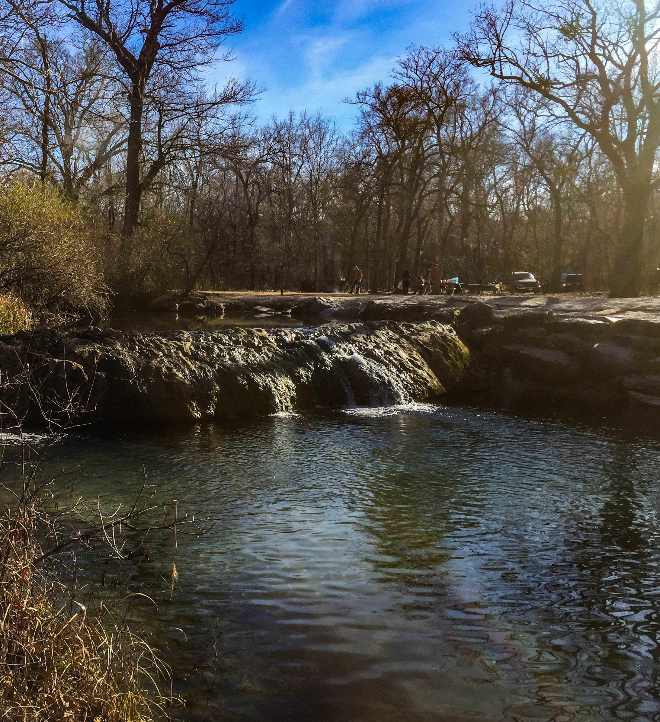 Visitors in picnic area near a rocky dam