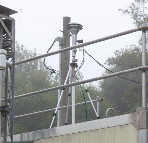 The real time particulate matter sensor is mounted on a tripod and sits atop the air quality shelter.