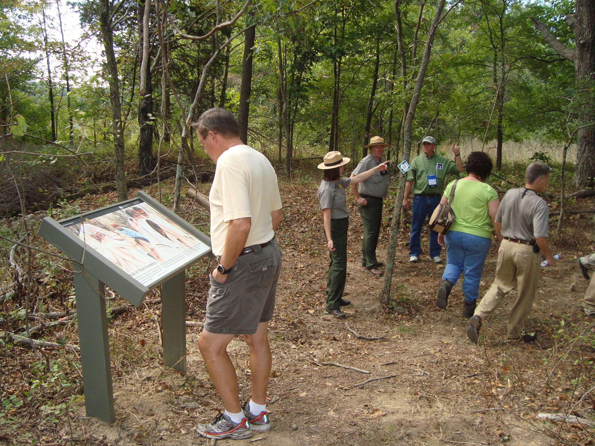 A group of people standing in a wooded area.
