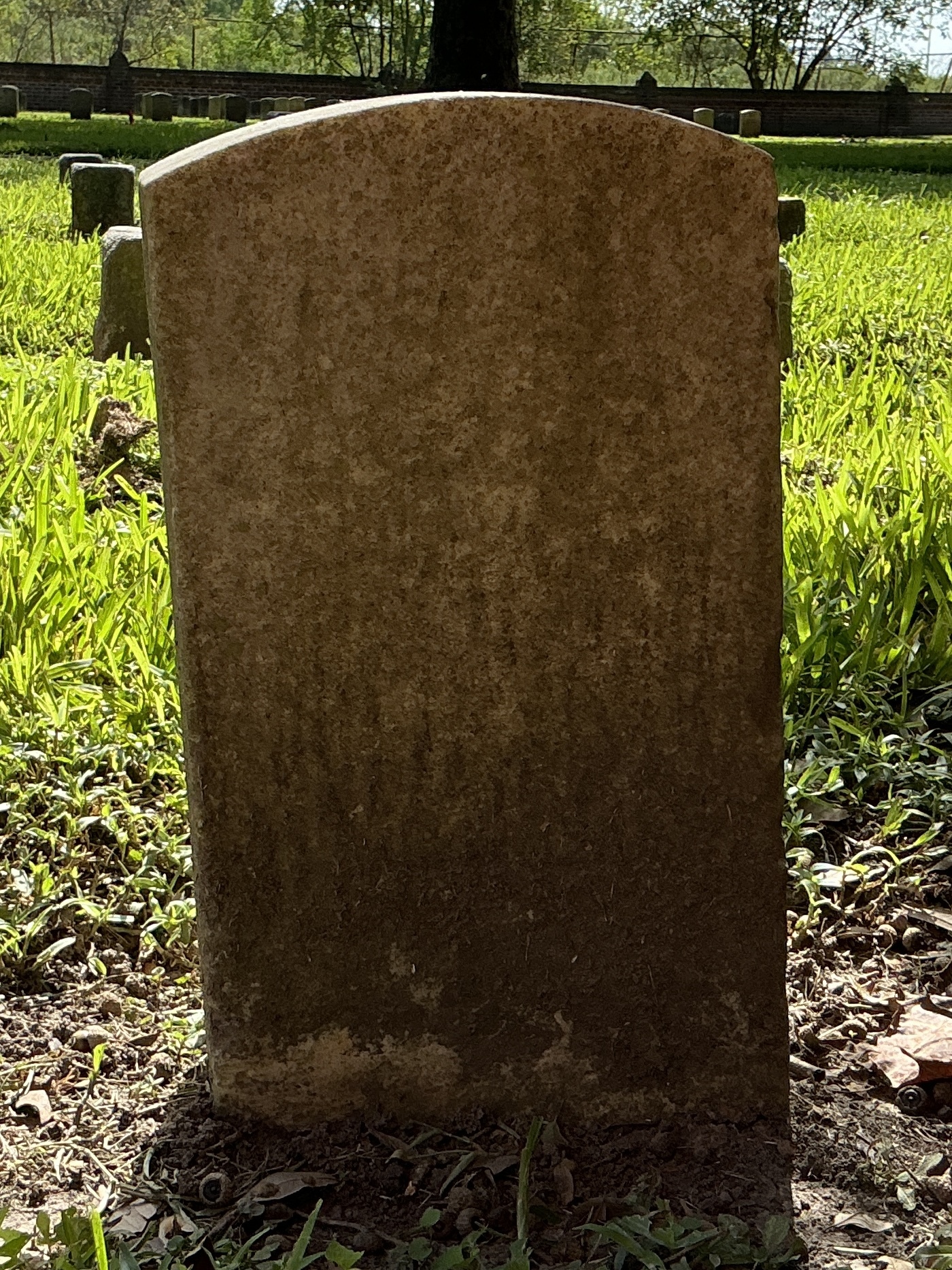 Back of historic upright marble headstone with recessed shield face.