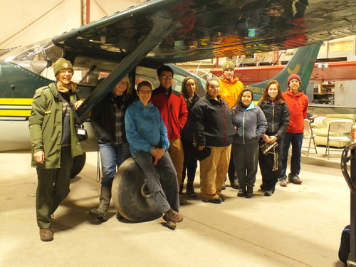 students standing in front of  a bush plane