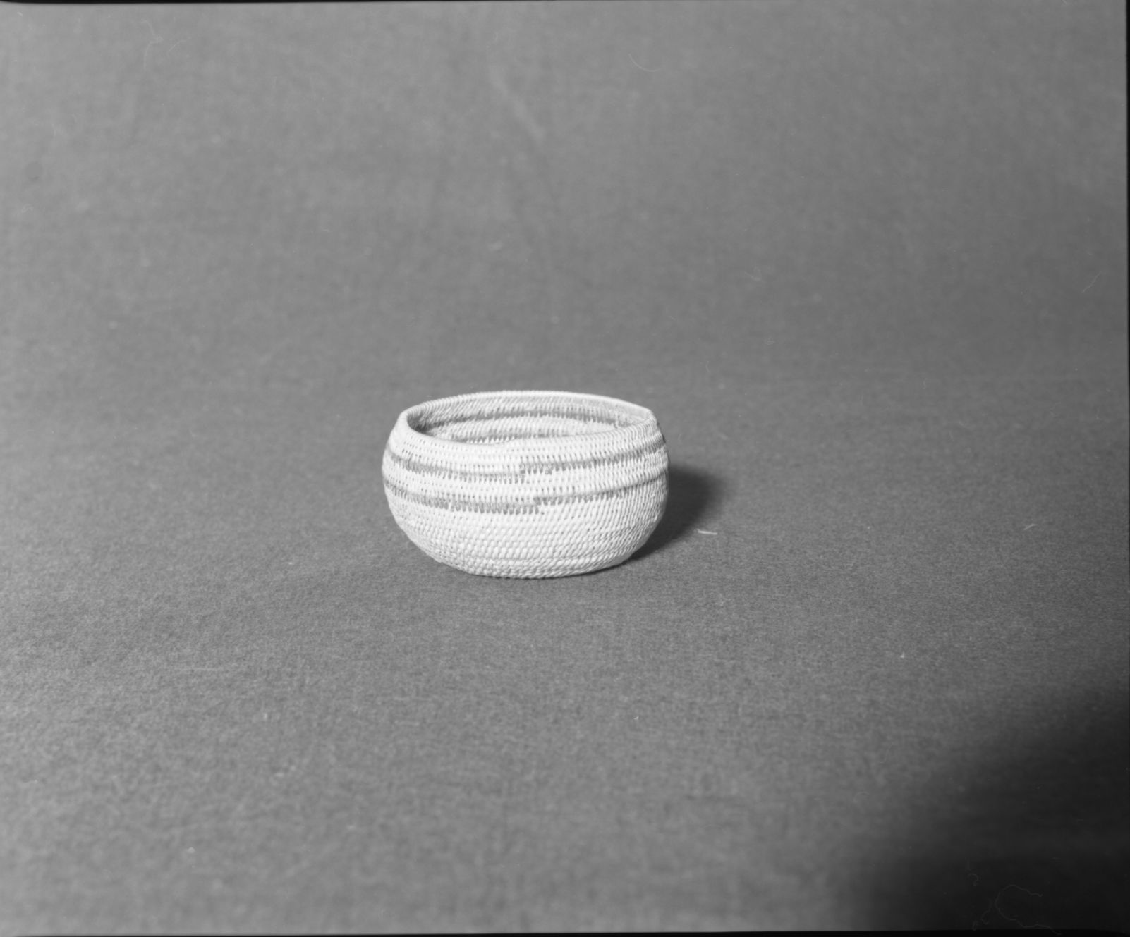 Mrs. Donald Segerstrom Collection. Object: Paiute basket. Dimensions: 4 1/2" x 2 1/4". Materials: split willow, bracken fern root. Technology: non-interlocking stitch, fag ends trimmed on work face, plain rim finish, start plugged with small piece of willow rod. Collection: ---. Photographed by Michael Dixon. Catalogued by Craig Bates and Barbara Beroza. Yosemite Collections, National Park Service.