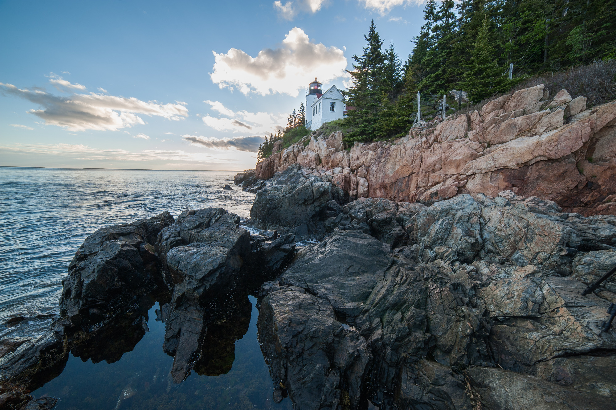 Small white lighthouse along a rocky coastline