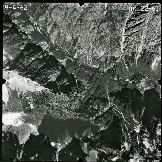 Black and white aerial photograph of glaciated mountain peaks and valleys.