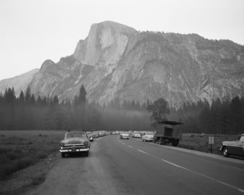 Cars parked along the road in Stoneman (Camp Curry) Meadow waiting for the "Firefall," Yosemite Valley. For official negative file of Yosemite.