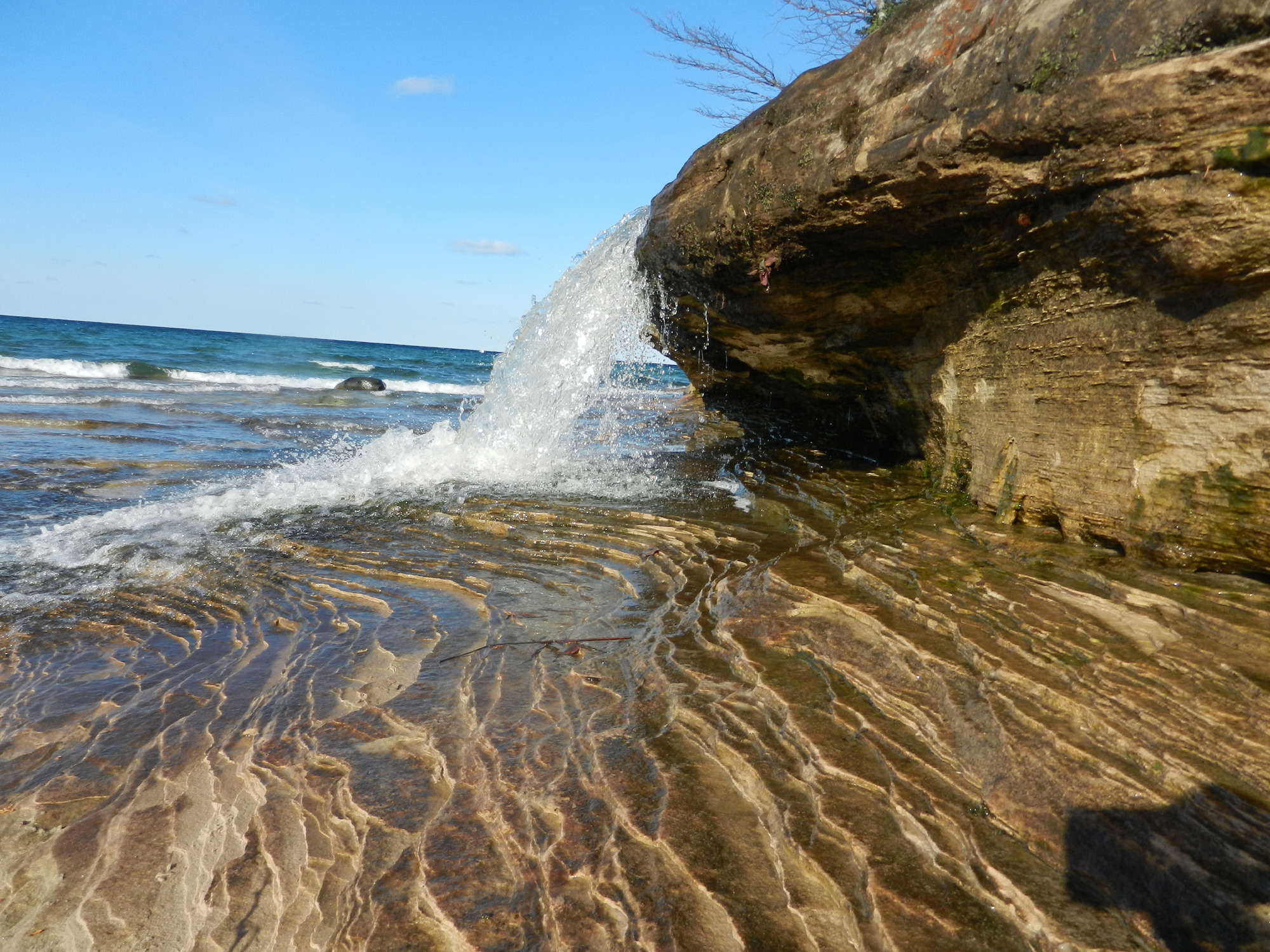 The tiny waterfall flows over a little rock ledge (2 feet high) into Lake Superior