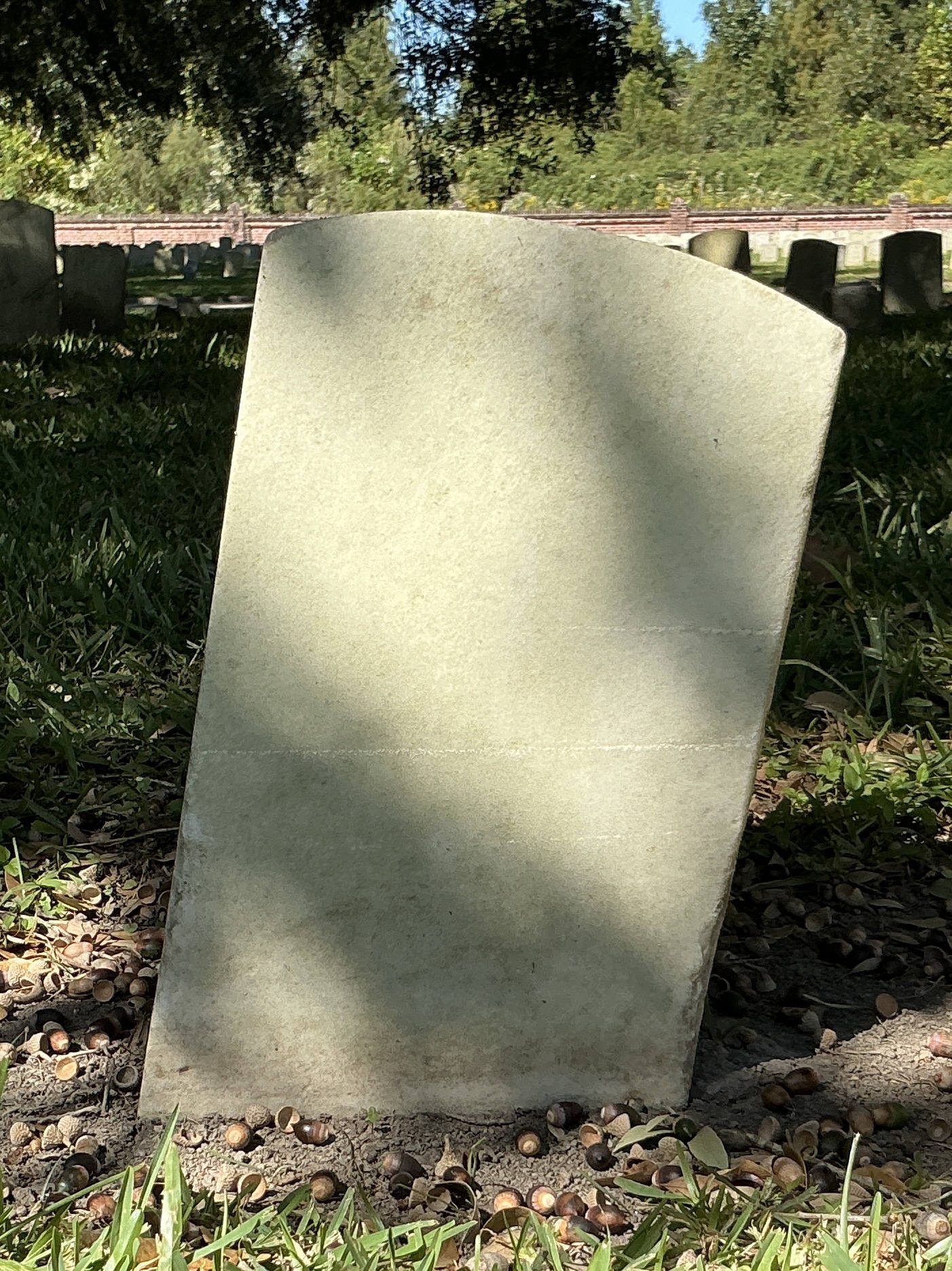 Back of historic upright marble headstone with recessed shield with recessed lettering face.