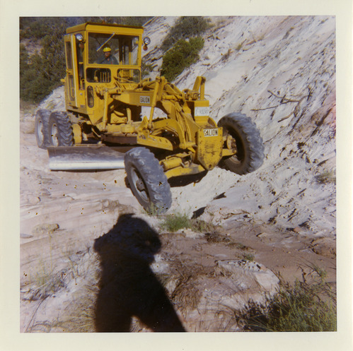 Tractor performing shoulder work along route 2 parking areas.