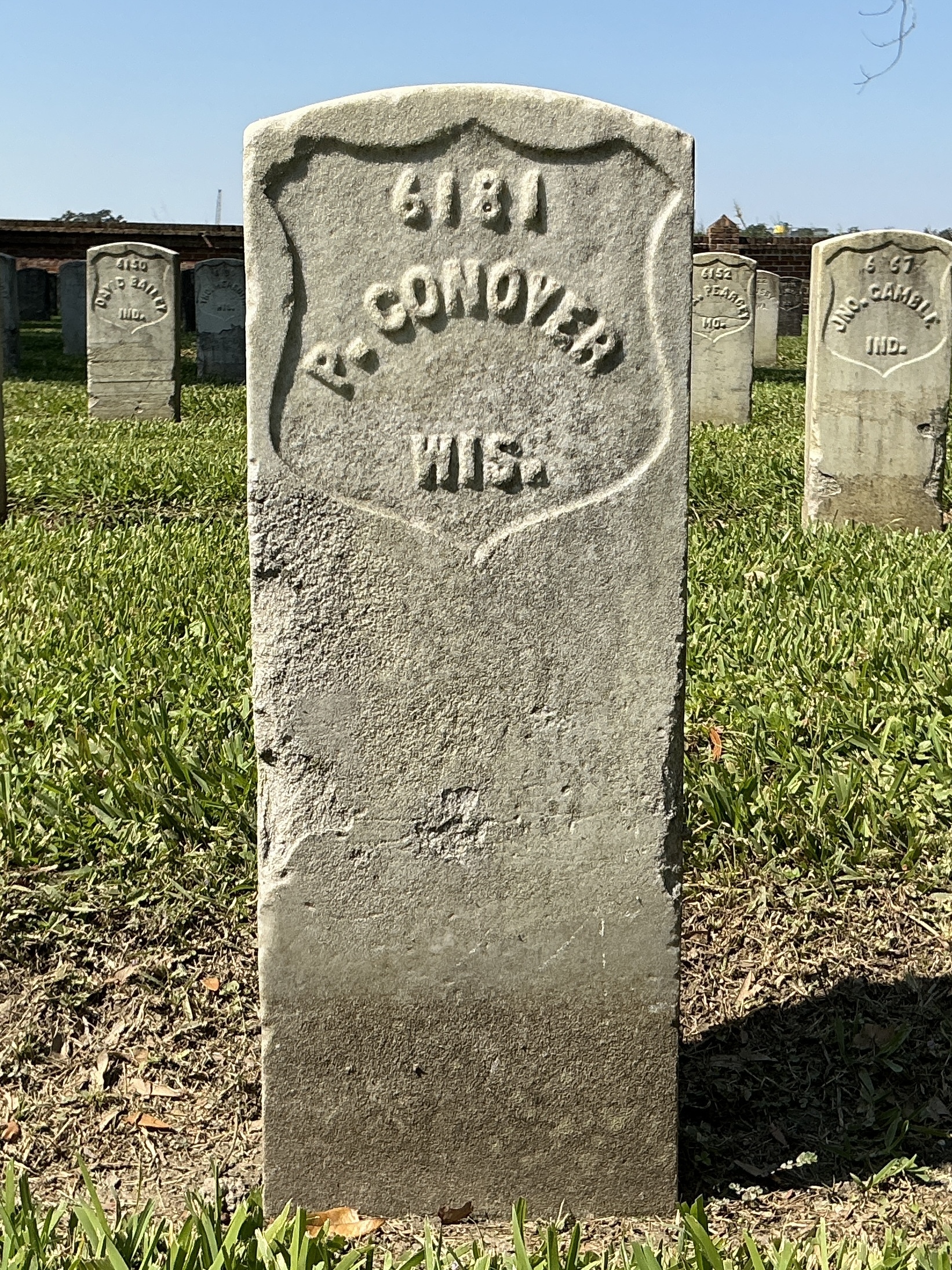 Front of historic upright marble headstone with recessed shield face.