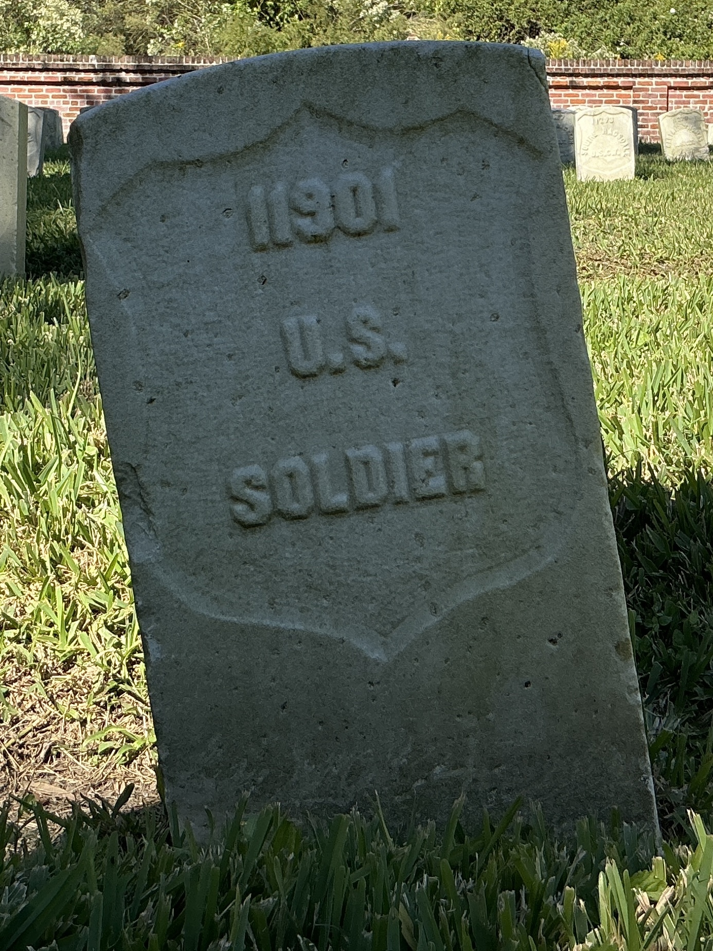 Front of historic upright marble headstone with recessed shield face.