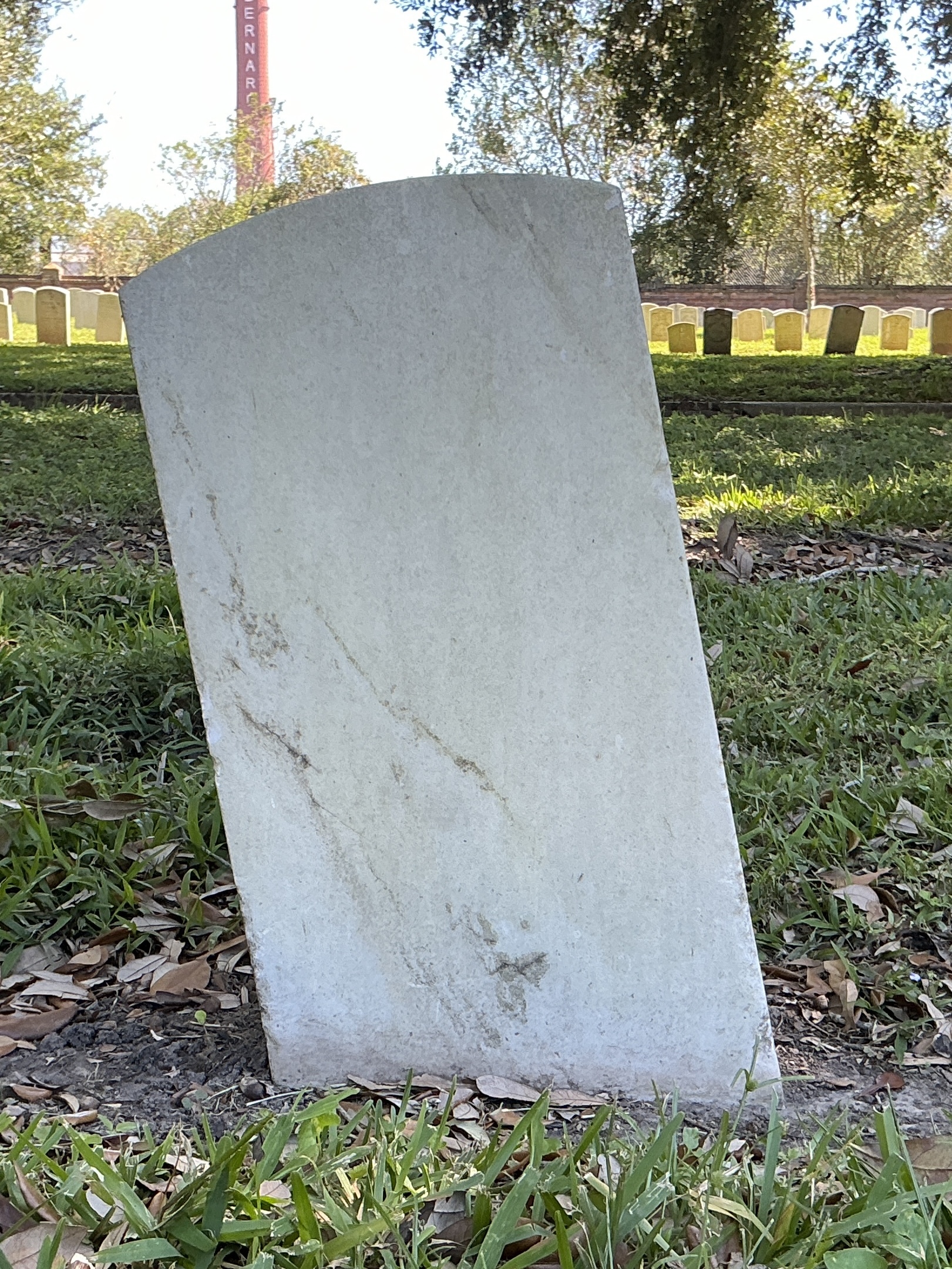 Back of historic upright marble headstone with recessed shield face.