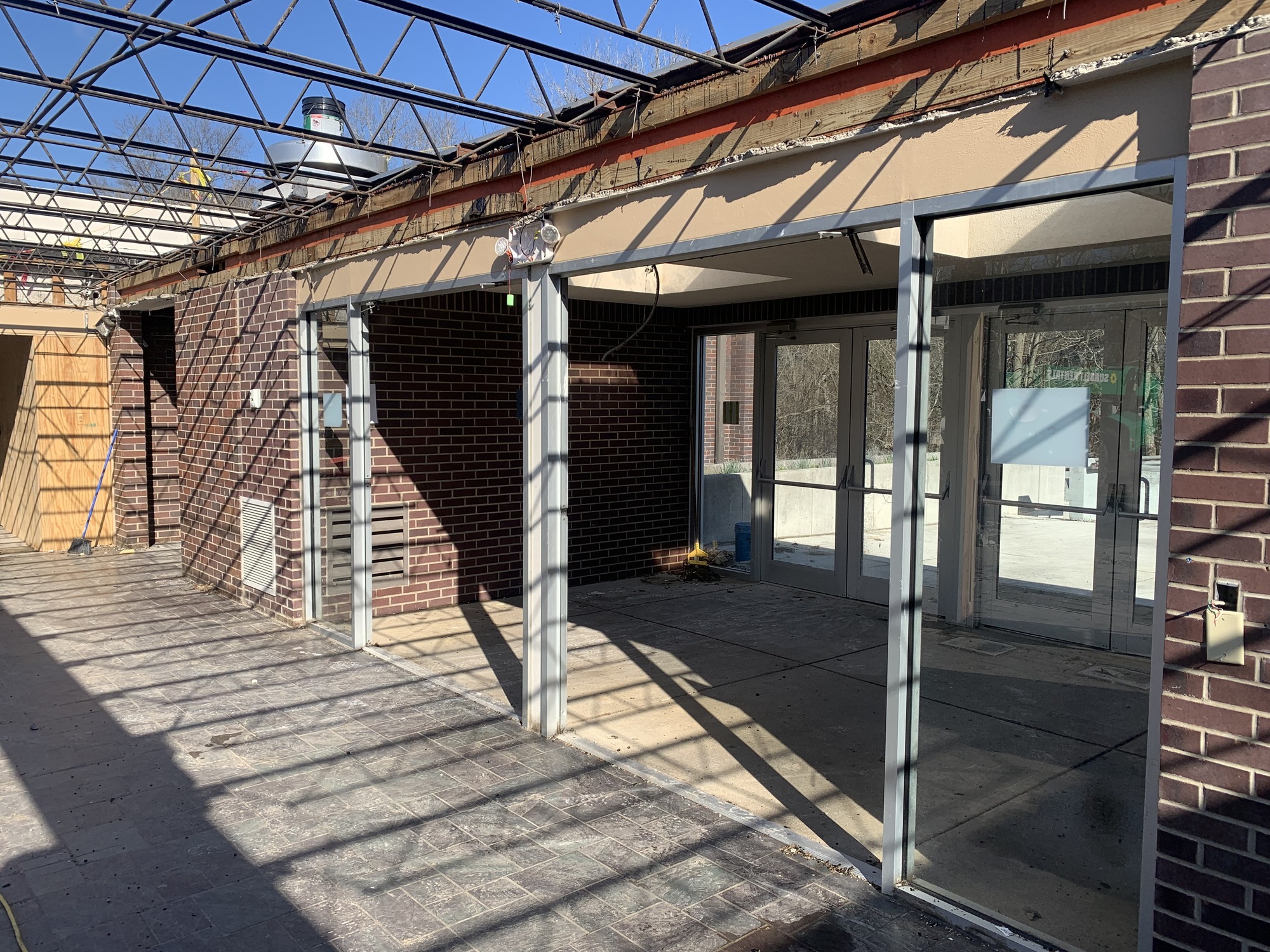 A metal framed entry way in a brick building with no roof.