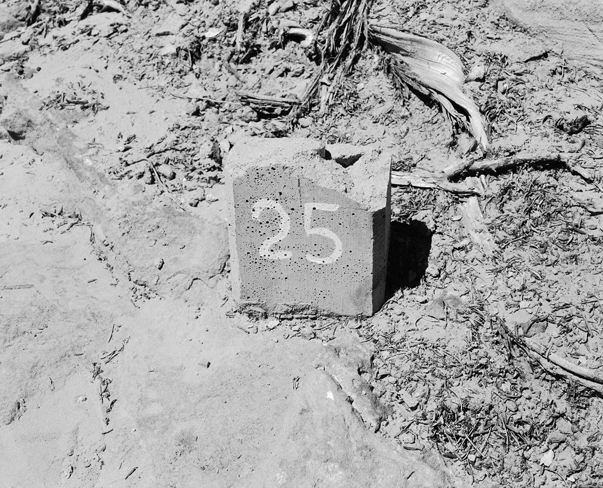 Vandalism on Canyon Overlook Trail, shows cement block with #25 painted on with top broken off.