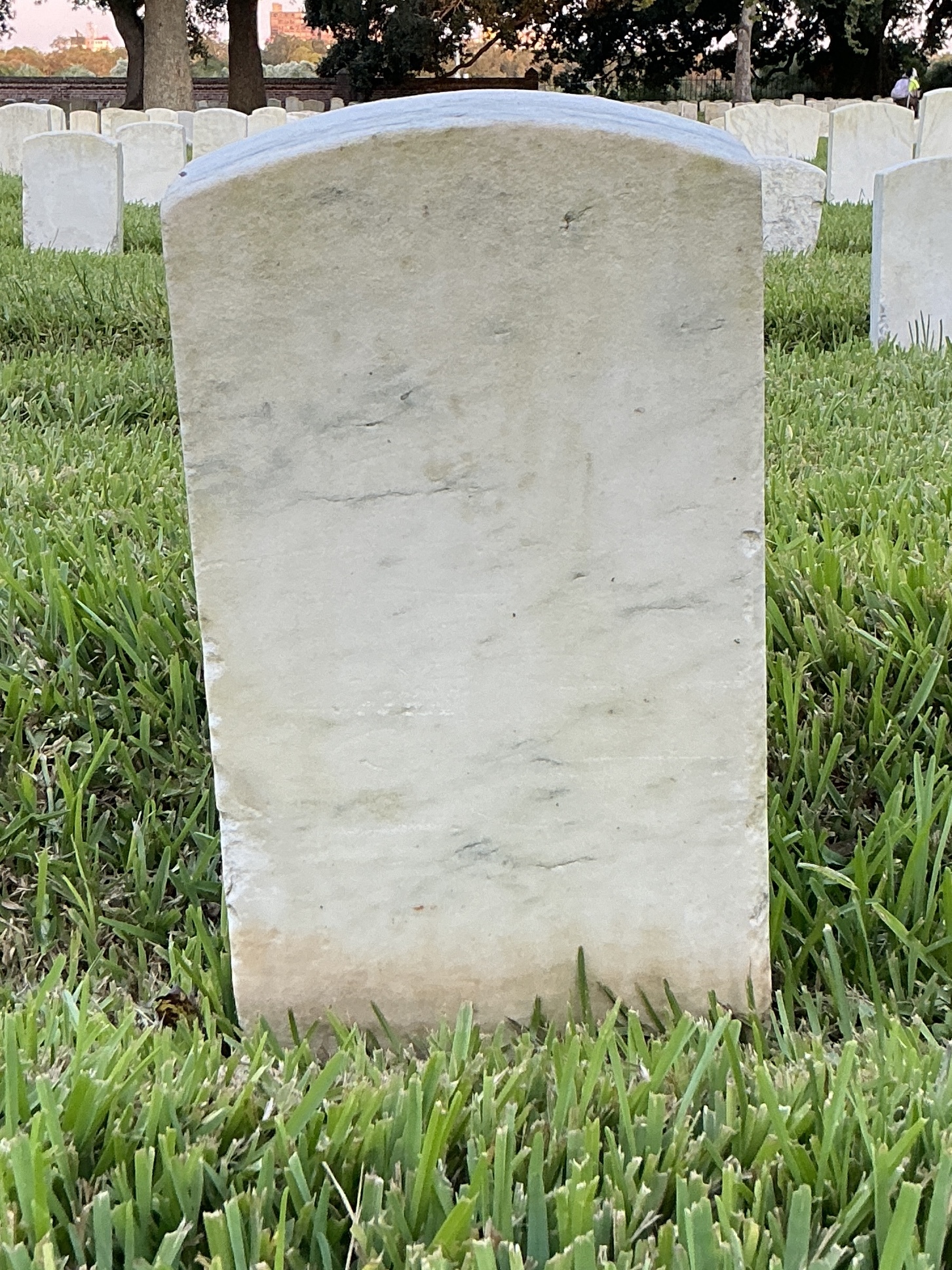Back of historic upright marble headstone with recessed shield face.