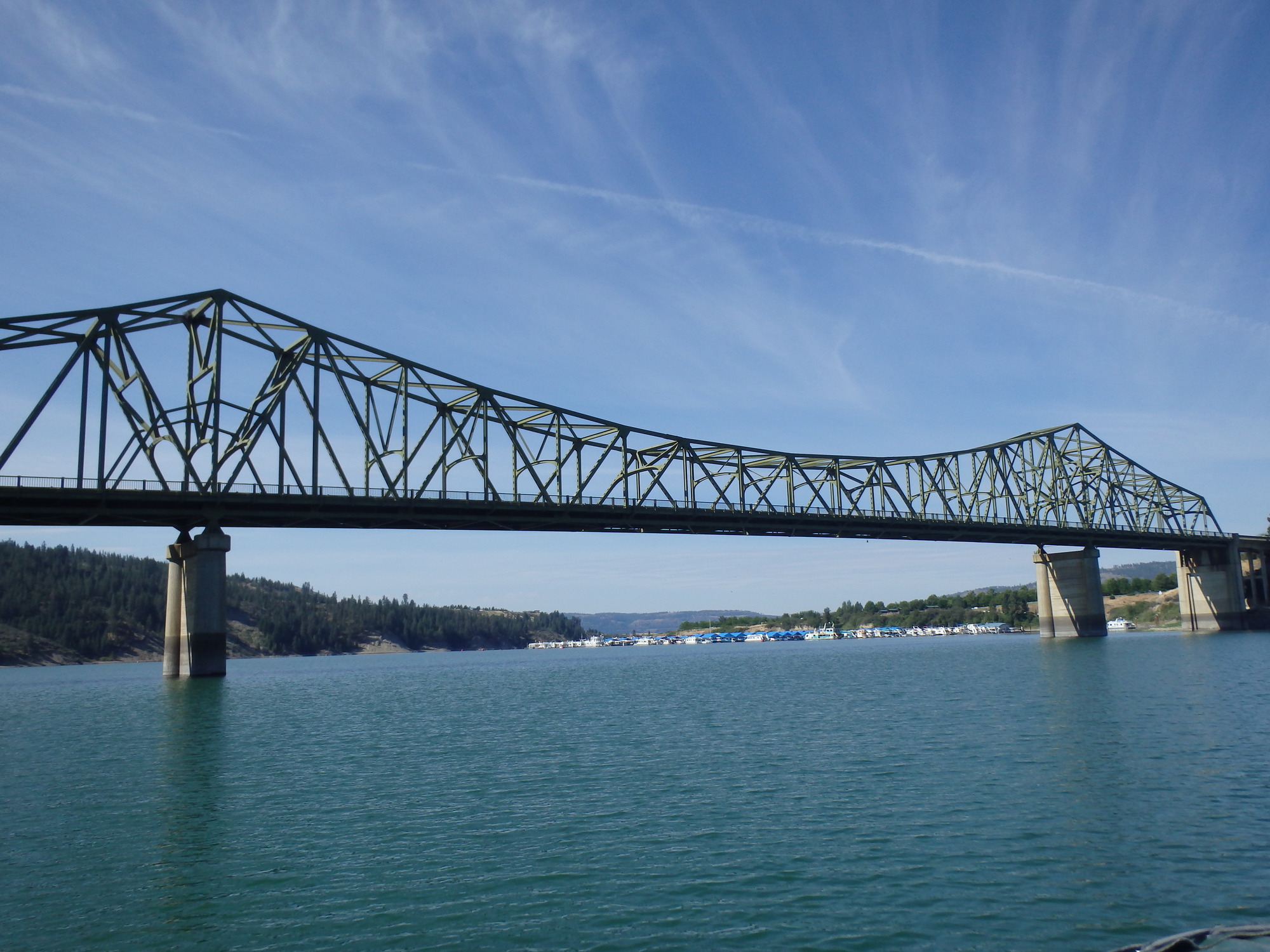 Color photograph of a metal bridge spanning a river