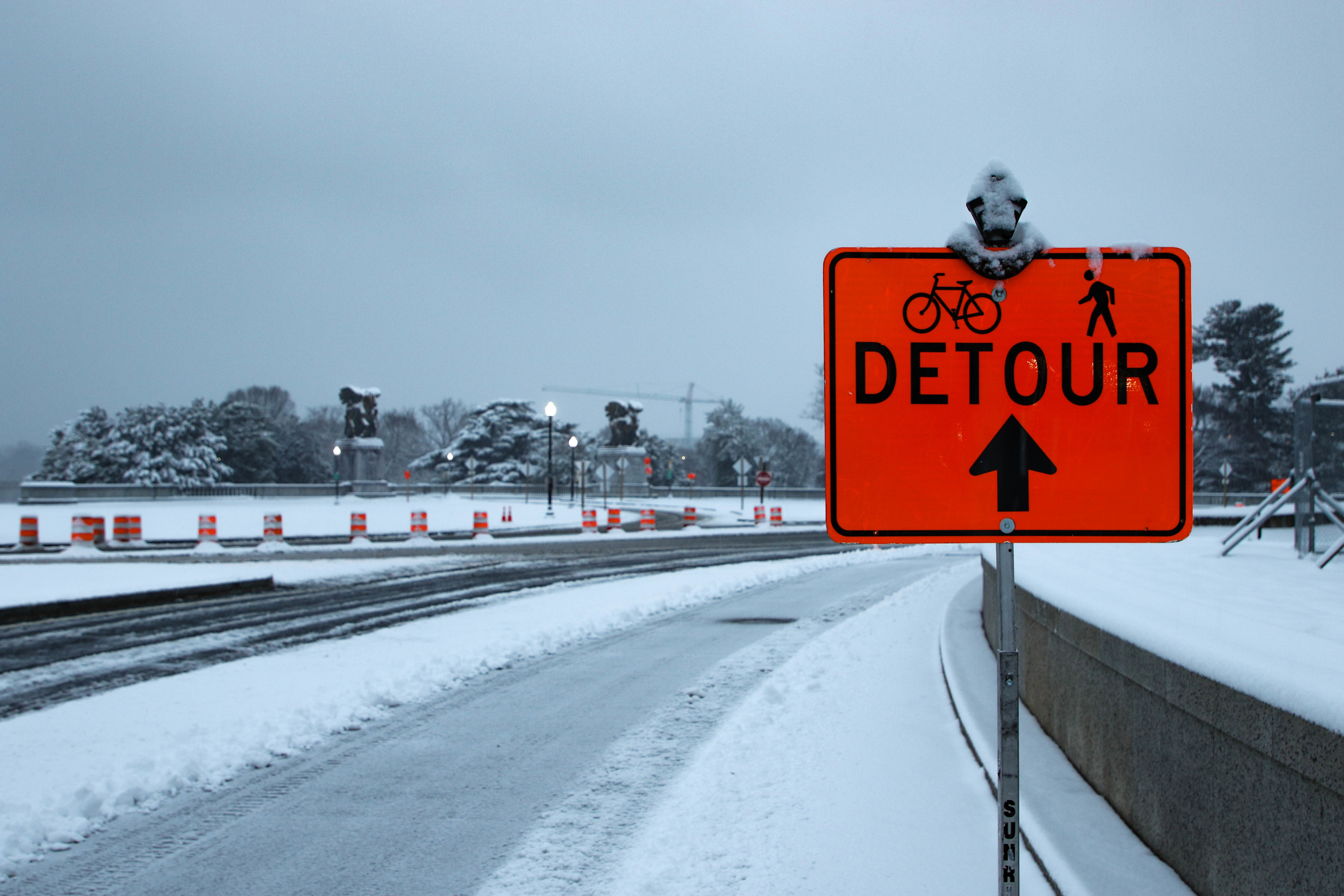 Detour sign for bikes and pedestrians covered in snow