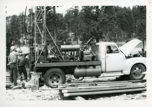 Two men with truck mounted drilling rig