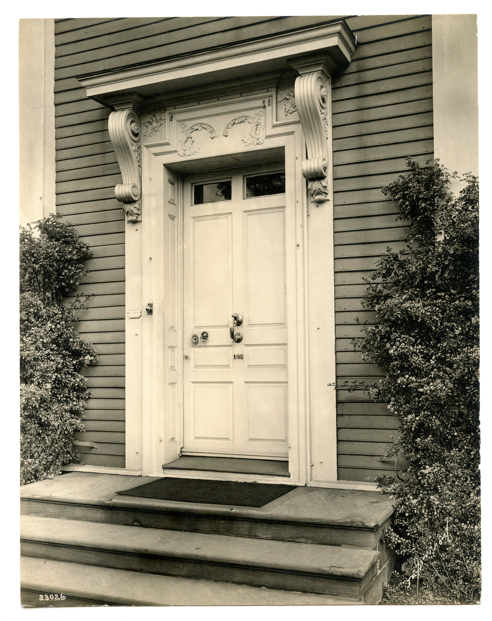 Close up of door on old house with intricate makings above the door.