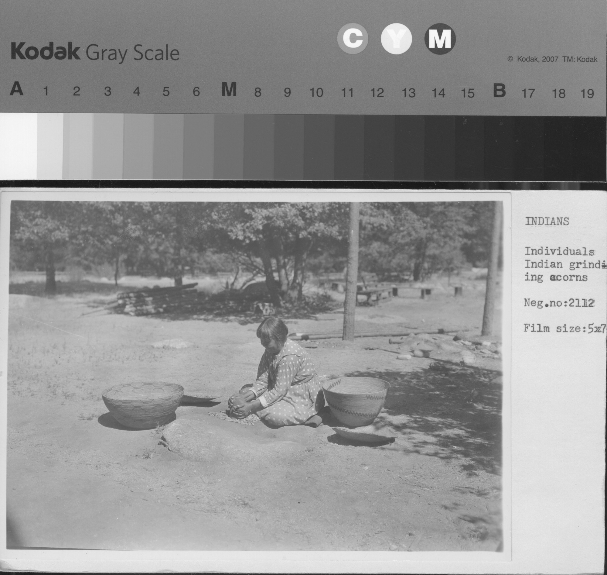 Native Americans grinding acorns