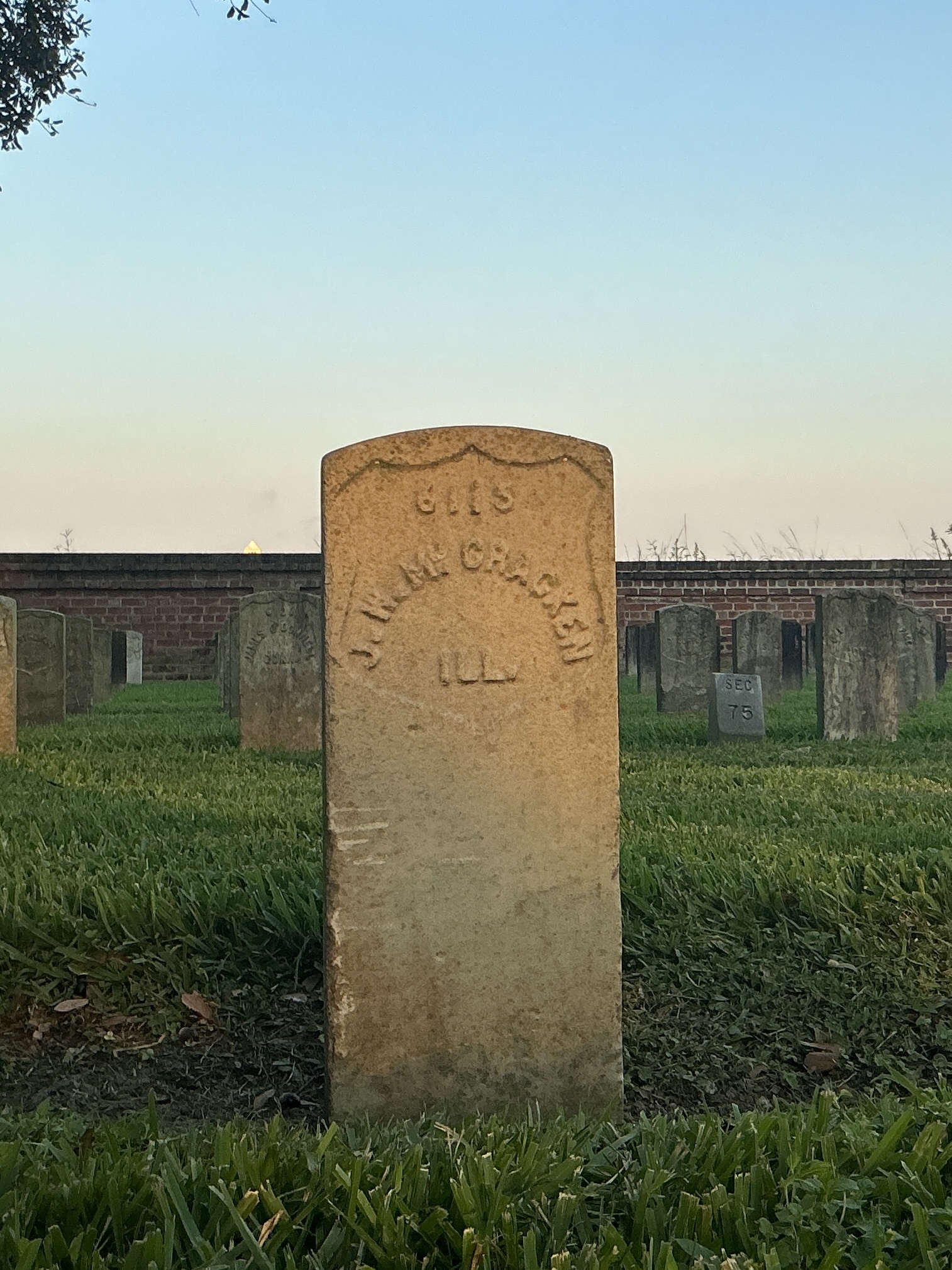 Front of historic upright marble headstone with recessed shield face.